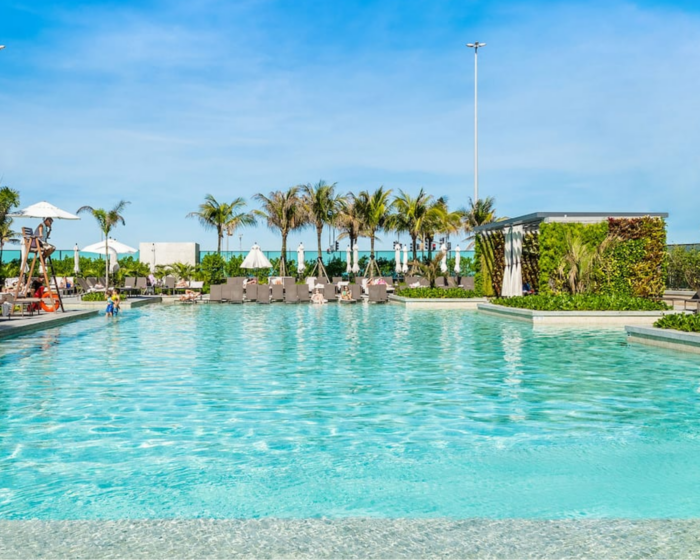 Vista da piscina do hotel Grand Hyatt em ambiente diurno. Ao fundo, árvores baixas. À esquerda, um salva-vidas.