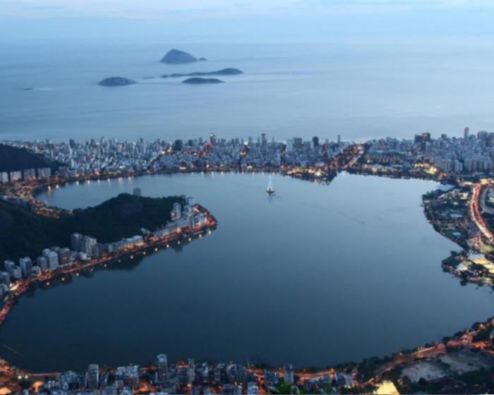 Vista aérea da Lagoa Rodrigo de Freitas cercada por prédios e mato.