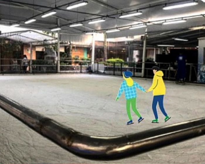 Foto de um rinque de patinação no gelo vazio com uma ilustração de duas pessoas patinando.